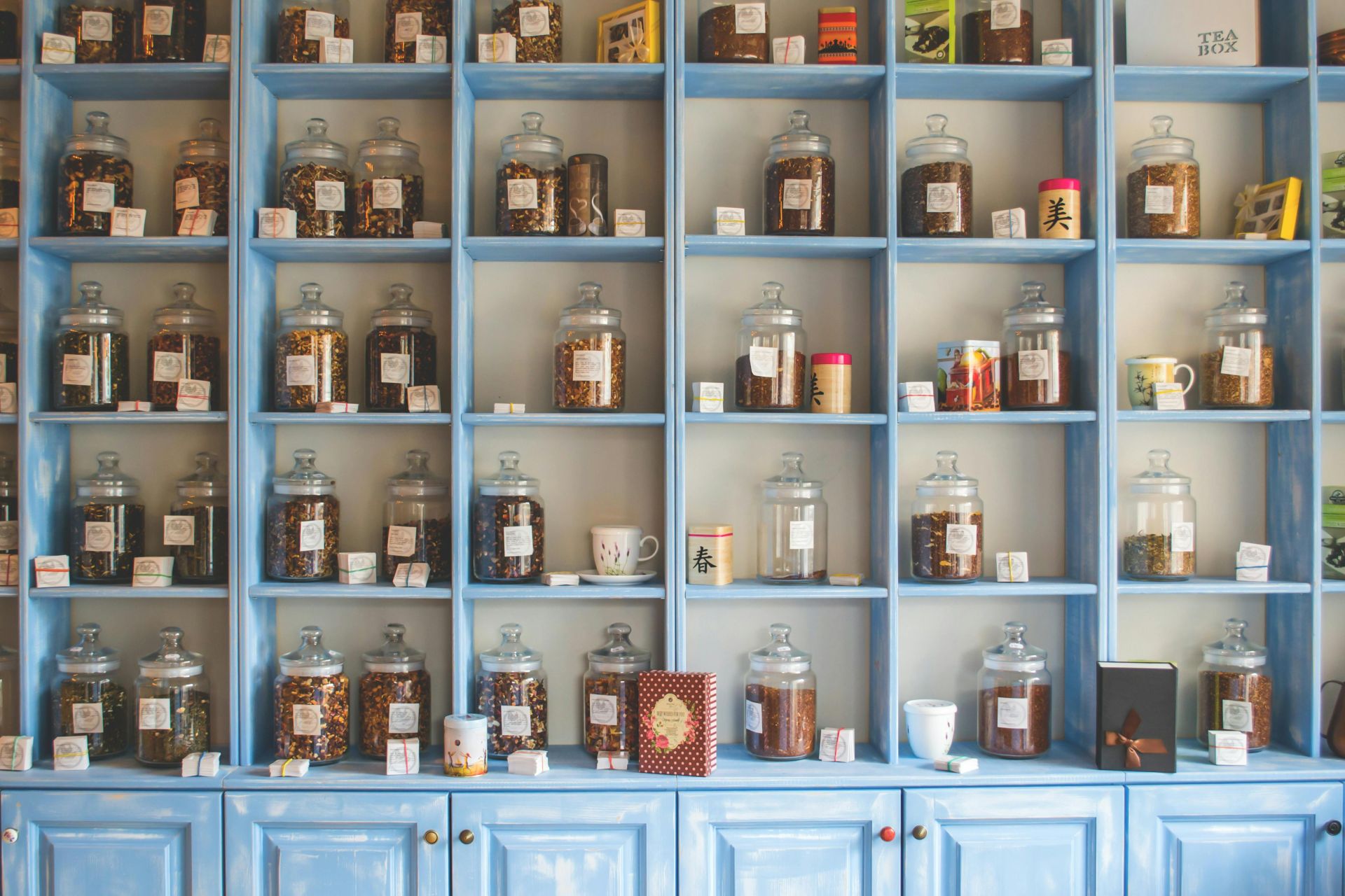 Assorted Tea Jars on Blue Shelf Cabinets