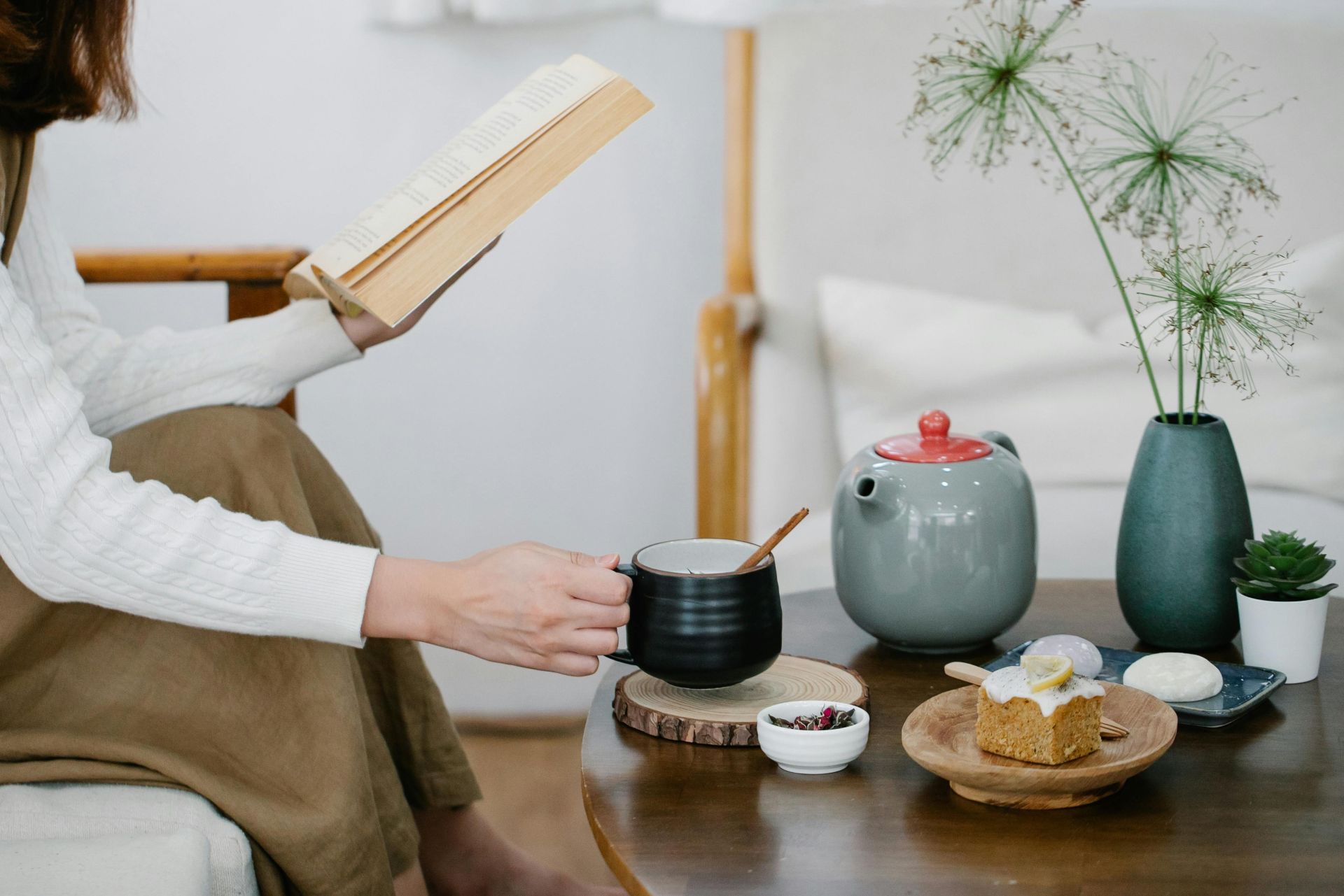 Young Woman Reading Book and Having Cup of Tea