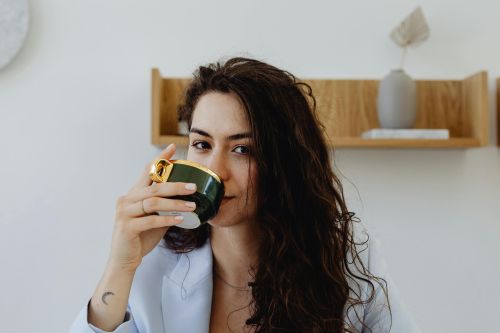 Close-up of a woman savoring a beverage, creating a cozy atmosphere.