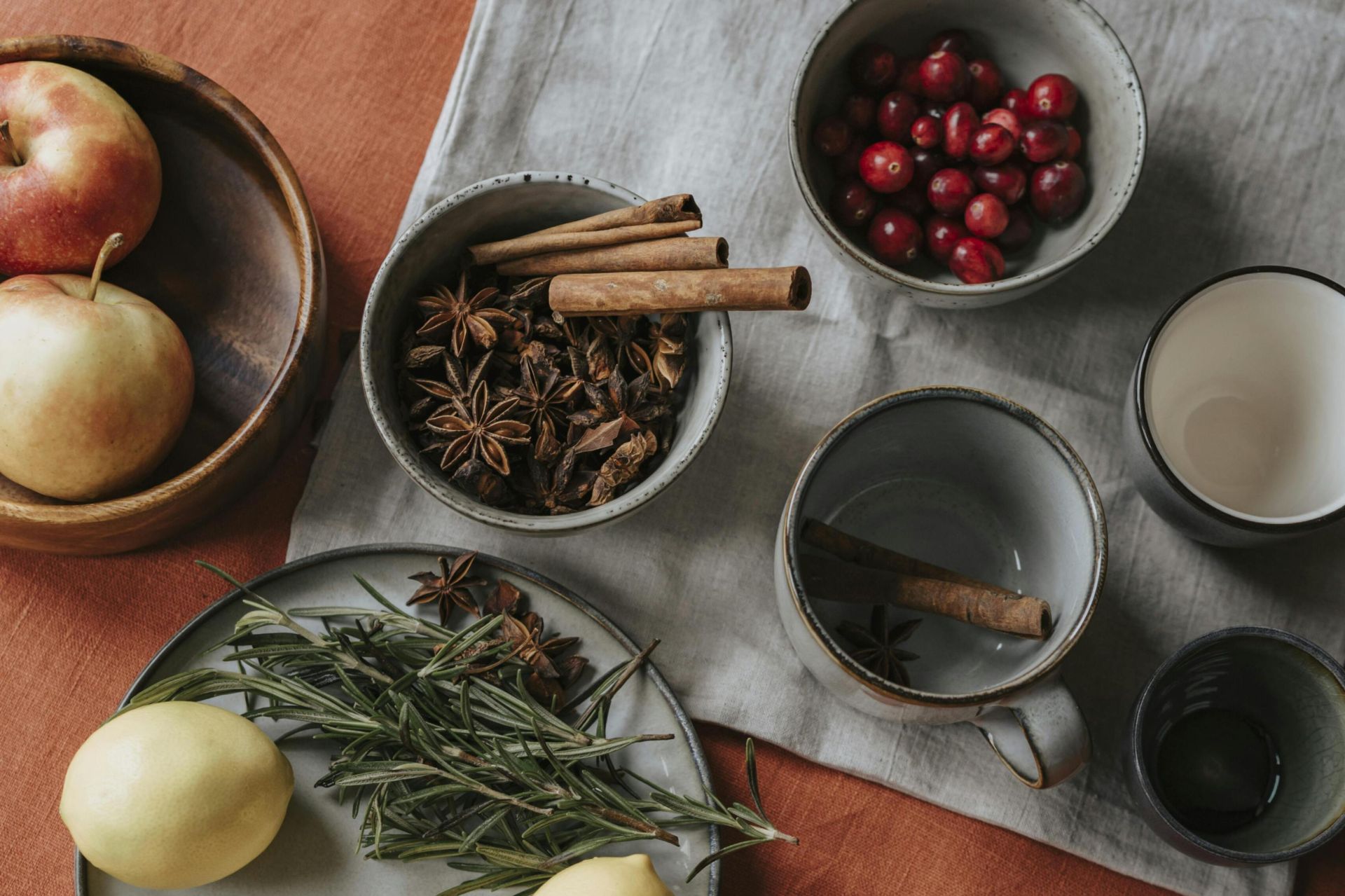 Flatlay of apples, lemons, star anise, and cinnamon creating a rustic still life setup.
